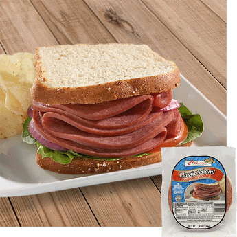 A Halal Beef salami sandwich with white bread red onion, tomato, and lettuce on a white plate with some potato chips behind to the left. A pack of Midamar Halal Classic Salami is overlayed in the bottom right corner.