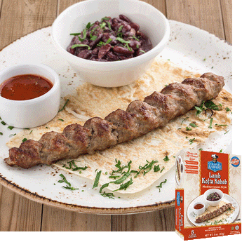lamb kofta kabab resting on a thin piece of bread, beside it is small bowl with a red sauce and slightly larger white bowl with chopped olives. The product is garnished with chopped cilantro. In the bottom right hand corner is an image of the product package