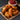 A pile of Halal Chicken tenders on a wooden cutting board a bowl of ketchup is above them.