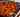 A floral green bowl of golden-brown pieces of fried chicken, fresh chunks of green, yellow, and red, bell peppers and pineapple. All coated in homemade sweet and sour sauce and served over rice on a blue placemat.