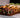 A serving board with an assortment of pastrami rollups and various flavors of wraps like tomato-basil, garden herb, and plain tortilla with various fillings like spinach, American cheese, and Halal pastrami.
