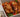 Top down shot of juicy halal grilled chicken served on a bed of sliced baked tomato, onion, peppers, and fresh basil. Served with sliced sourdough and ricotta cheese.