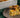 I slice of breakfast casserole of egg, cheese, and diced onion, mushroom, and tomato with a crumble of savory Halal breakfast sausage mixed throughout..