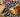 Top-down image of a breakfast burrito sliced in half, packed full of scrambled egg, cheese, veggies, and bits of Halal sausage and bacon. Next to a freezer bag of wrapped burritos