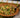 A brown decorative bowl filled with tender pasta coated in a decadently creamy sauce, peas, and diced Halal beef bacon.