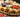 A platter full of kabab wraps, full of tomato, onion, seasoned chickpeas, beef or chicken seekh kebabs, garlic sauce, and spinach, then grilled to a crispy golden-brown.