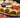 A platter full of kabab wraps, full of tomato, onion, seasoned chickpeas, beef or chicken seekh kebabs, garlic sauce, and spinach, then grilled to a crispy golden-brown.