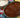 A large green dish full of rich and smooth mole sauce and shredded Halal chicken, served with white rice and tortillas