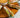 A Wood platter of Spring rolls made with carrot, cucumber, lettuce, mint, Halal chicken, and rice noodles rolled up in rice paper wraps. Served with creamy peanut sauce and savory pepper sauce.