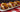 A plate of three Chili Cheese Dogs made with Halal smoked beef franks covered in homemade chili and melty shredded cheese.