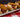 A plate of three Chili Cheese Dogs made with Halal smoked beef franks covered in homemade chili and melty shredded cheese.