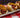 A plate of three Chili Cheese Dogs made with Halal smoked beef franks covered in homemade chili and melty shredded cheese.