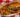A banzai burger copycat of Halal beef patty in banzai glaze, sauce, cheese, pineapple, tomato, and lettuce on a brioche bun served in a basket with fries