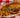 A banzai burger copycat of Halal beef patty in banzai glaze, sauce, cheese, pineapple, tomato, and lettuce on a brioche bun served in a basket with fries
