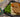 Two golden brown Halal chicken patties, topped with homemade brown gravy and served over creamy homemade mashed potatoes with organic green beans