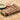 Beef seekh kabab resting on a bed of lettuce, it is garnished with onions and tomatoes, beside them is a blue bowl with a light green sauce