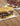 two deli sandwiches sit on white plates, one features roast beef and the other pastrami