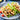 three tacos are lined up on a plate. In the tacos are diced chicken, avocado, tomatos and lettuce. 