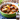 A bowl of beef stew with potatos and carrots. A package of united steaks beef stew is overlaid in the bottom right corner. 