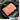Ground chicken on a black plate with herbs, branded packaging in the corner.