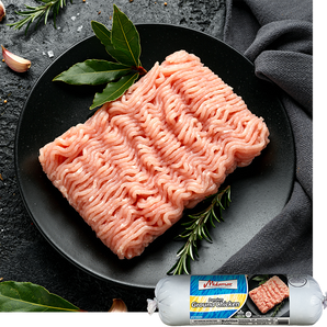 Ground chicken on a black plate with herbs, branded packaging in the corner.