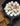 charred marshmallows rest in a melted pool of chocolate inside of a cast iron pan. Beside the pan is a small pile of graham crackers