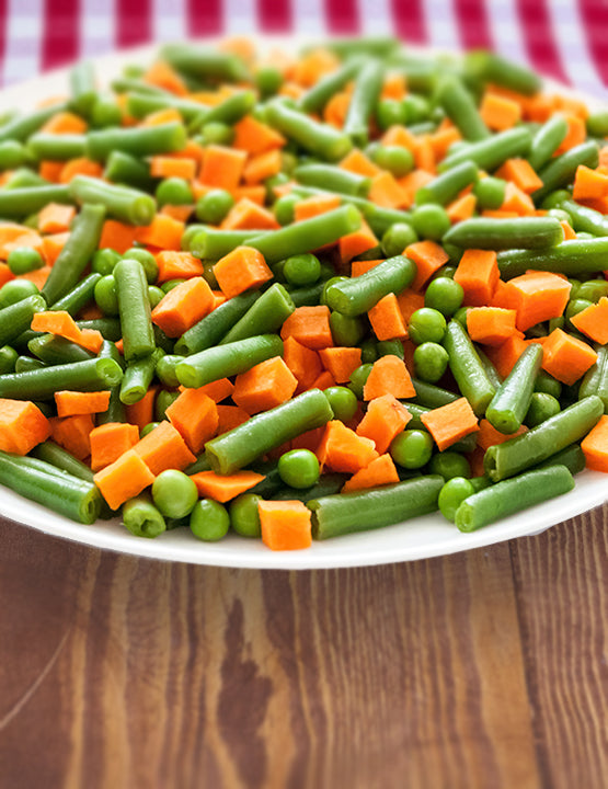 a large shallow plate covered with peas, green beans, and diced carrots